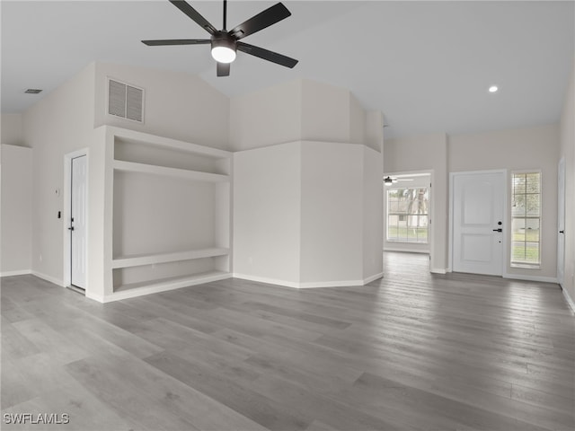 unfurnished living room featuring built in shelves, high vaulted ceiling, ceiling fan, and hardwood / wood-style floors