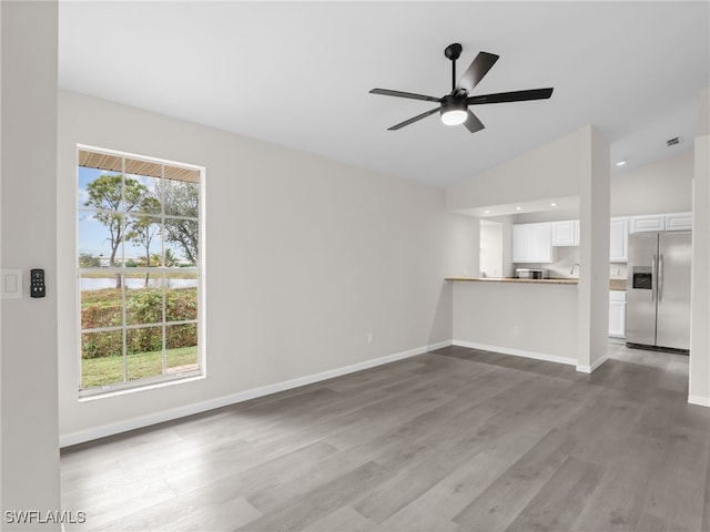 unfurnished living room with ceiling fan, wood-type flooring, and lofted ceiling