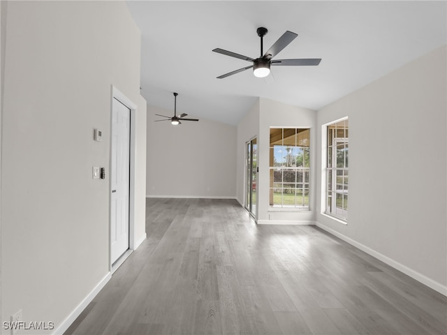 unfurnished room featuring hardwood / wood-style flooring, vaulted ceiling, and ceiling fan