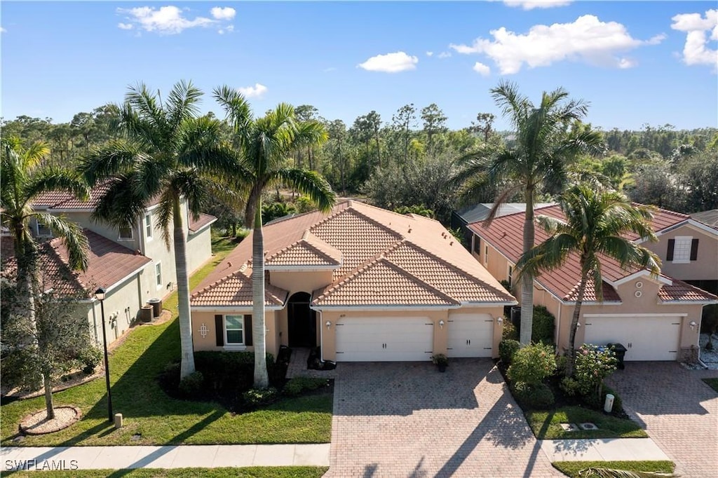 mediterranean / spanish home with a front yard and a garage