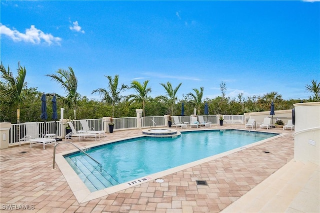 view of swimming pool with a hot tub and a patio