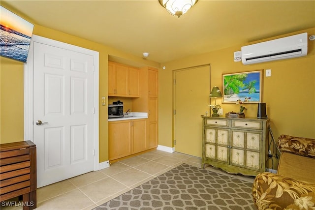 kitchen featuring light tile patterned floors, an AC wall unit, sink, and light brown cabinets