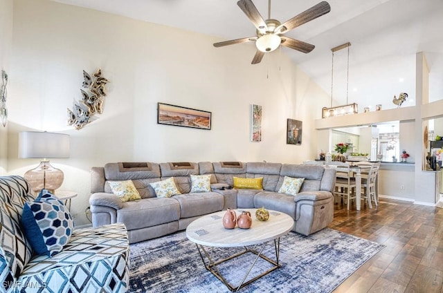 living room featuring ceiling fan, vaulted ceiling, and dark wood-type flooring