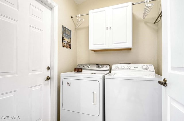 laundry room with cabinets and washing machine and clothes dryer