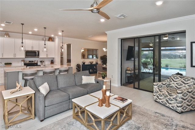 living room with visible vents, recessed lighting, and ornamental molding