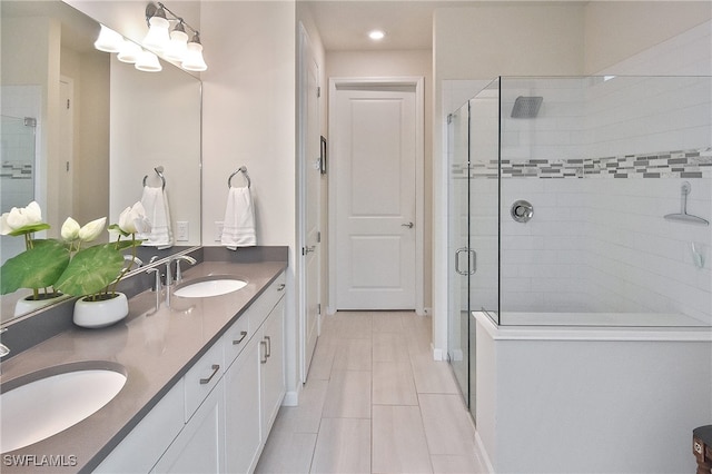 bathroom featuring double vanity, a shower stall, baseboards, and a sink