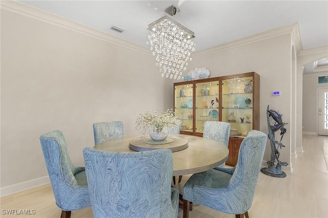 dining area with crown molding and a chandelier