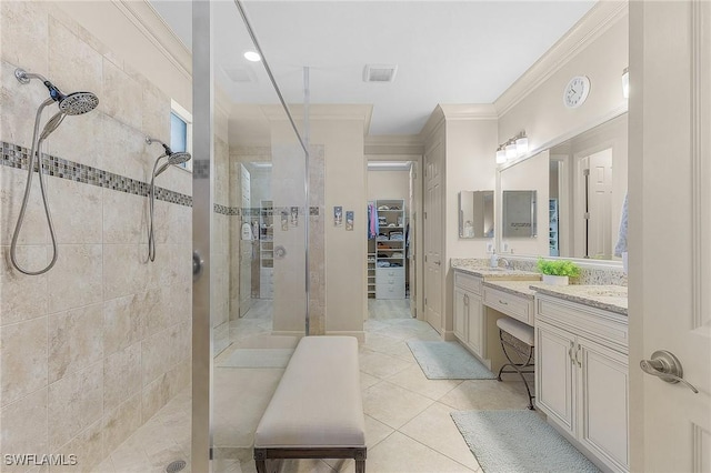 bathroom featuring crown molding, a tile shower, tile patterned floors, and vanity