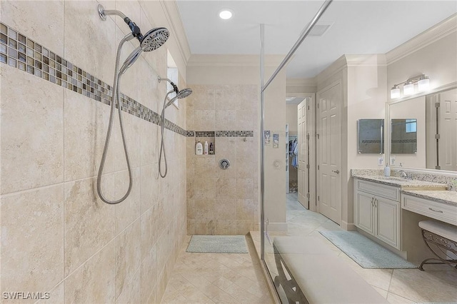 bathroom with vanity, tile patterned floors, crown molding, and tiled shower