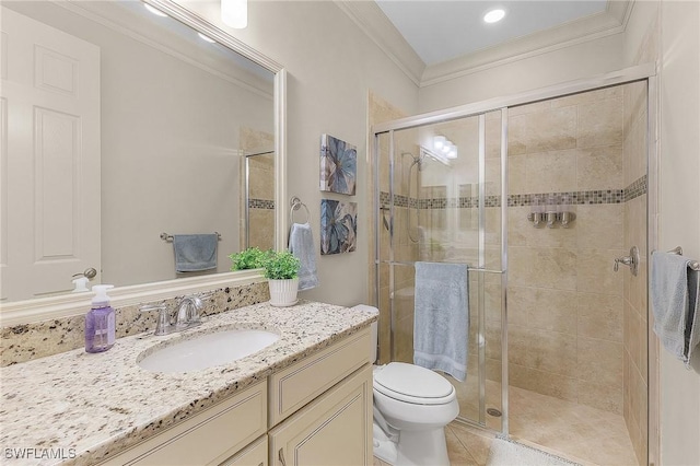 bathroom featuring toilet, a shower with shower door, tile patterned floors, crown molding, and vanity