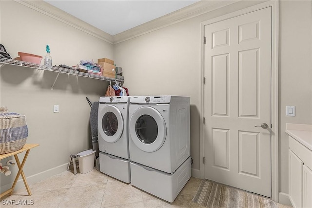 laundry area featuring light tile patterned floors, ornamental molding, and washing machine and clothes dryer