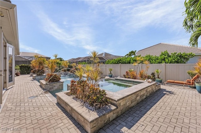 view of pool featuring an in ground hot tub, pool water feature, and a patio