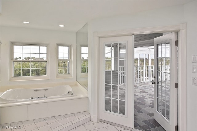 bathroom featuring tile patterned flooring, plenty of natural light, and a tub