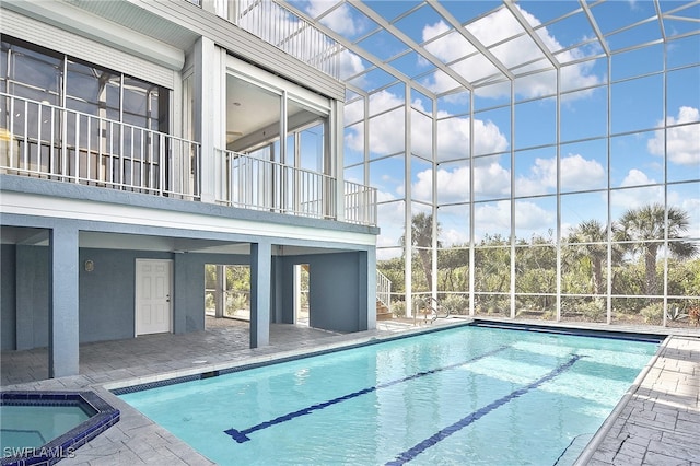 view of swimming pool with an in ground hot tub and a lanai