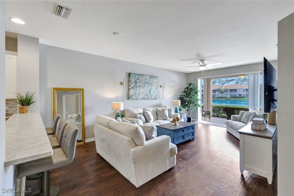 living room with ceiling fan and dark hardwood / wood-style floors