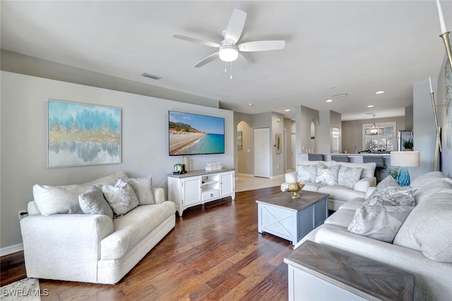 living room with ceiling fan and dark wood-type flooring