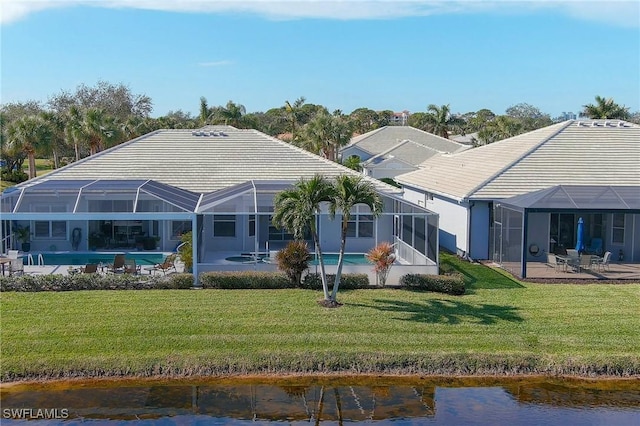 rear view of property with a lanai, a water view, a patio area, and a lawn