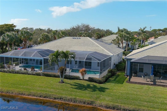 rear view of house with a patio, a lanai, and a water view