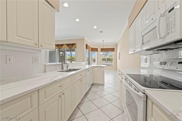 kitchen with white appliances, pendant lighting, light tile patterned floors, ornamental molding, and sink