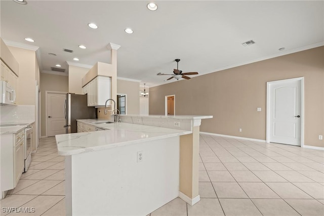 kitchen with sink, white cabinets, white appliances, kitchen peninsula, and backsplash