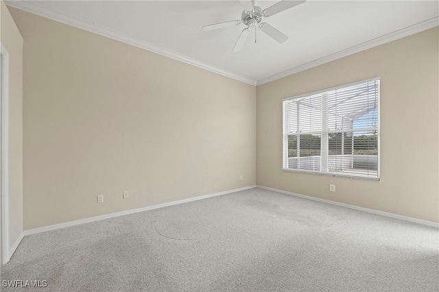 carpeted empty room featuring ceiling fan and crown molding