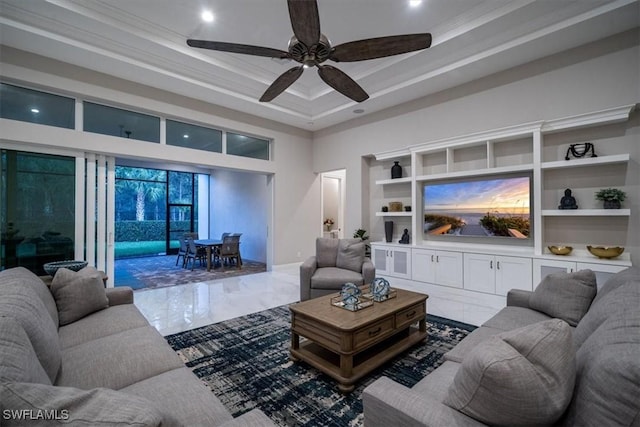 living room with a raised ceiling, ceiling fan, built in features, a high ceiling, and crown molding