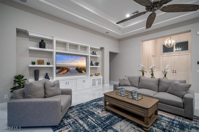 living room featuring built in shelves and ceiling fan with notable chandelier