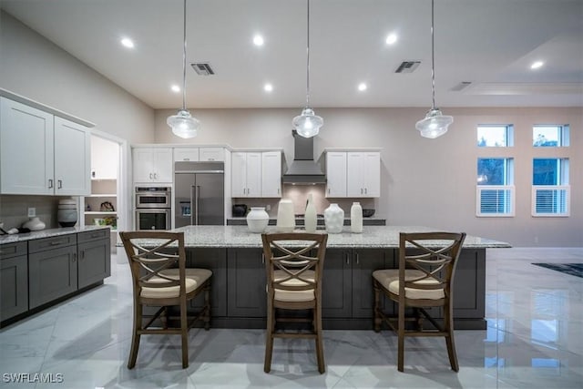 kitchen featuring a large island, stainless steel appliances, and wall chimney exhaust hood