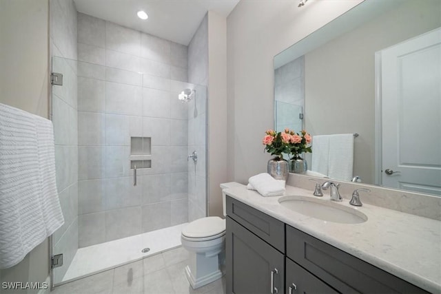 bathroom with toilet, vanity, and a shower with shower door