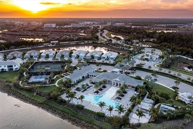 aerial view at dusk featuring a water view