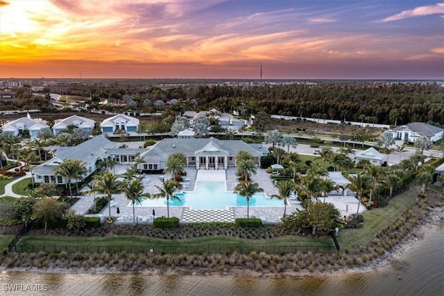 aerial view at dusk featuring a water view