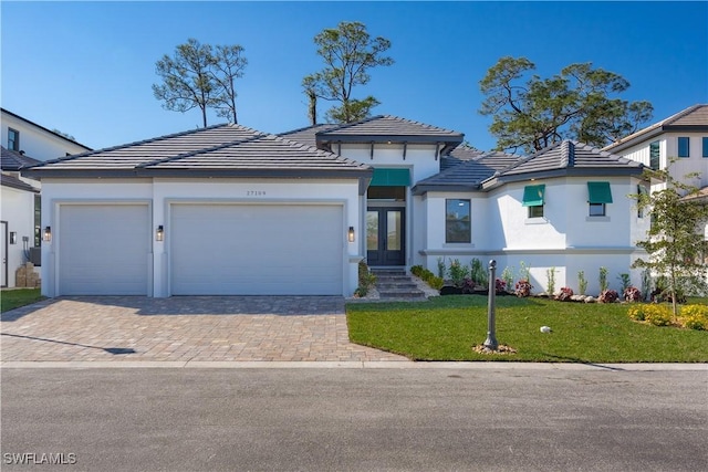 view of front of home featuring a garage, a front lawn, and french doors