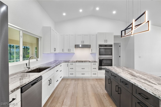 kitchen featuring stainless steel appliances, sink, white cabinets, hanging light fixtures, and high vaulted ceiling