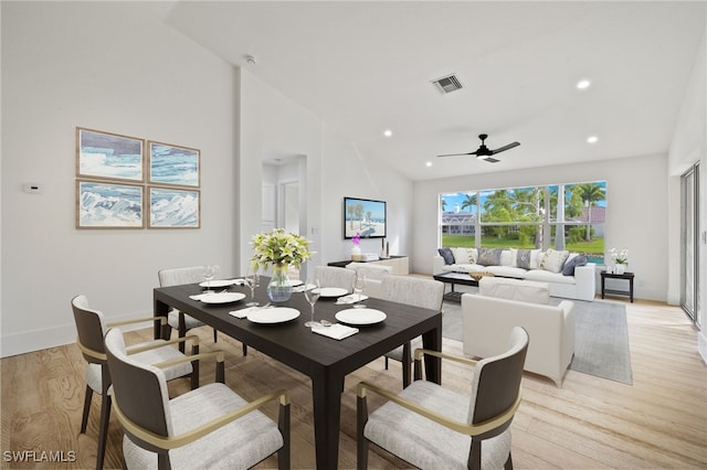 dining space with high vaulted ceiling, light wood-type flooring, and ceiling fan