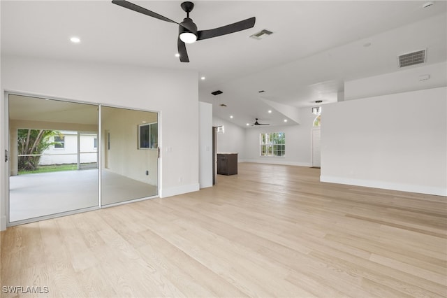 unfurnished living room featuring ceiling fan, light hardwood / wood-style flooring, lofted ceiling, and plenty of natural light