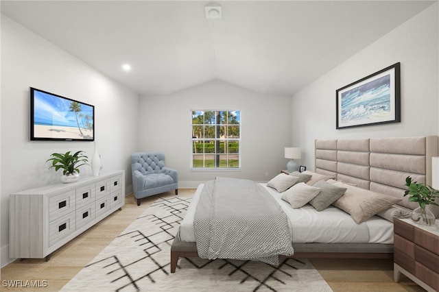 bedroom with light wood-type flooring and vaulted ceiling