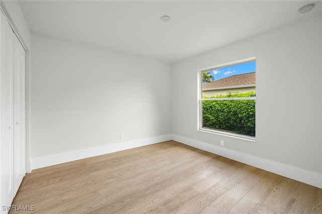 unfurnished bedroom with a closet and light wood-type flooring