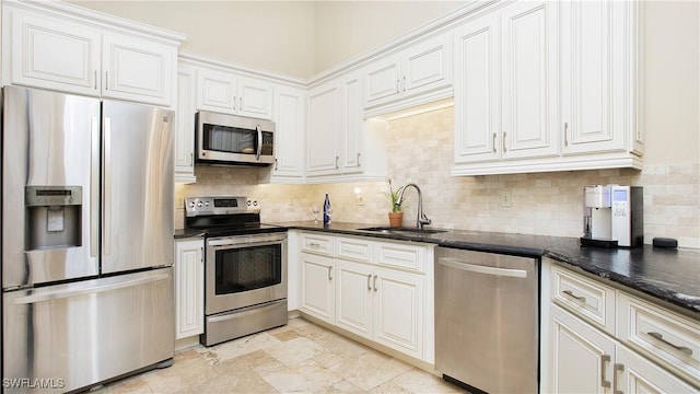 kitchen featuring white cabinetry, appliances with stainless steel finishes, sink, and backsplash