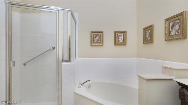 bathroom featuring vanity and independent shower and bath