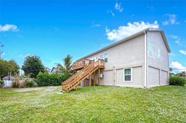 rear view of house featuring a wooden deck and a yard