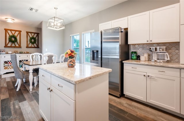 kitchen featuring stainless steel fridge with ice dispenser, backsplash, a kitchen island, pendant lighting, and white cabinets