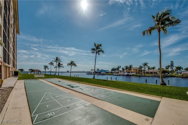 view of home's community with a water view and a yard