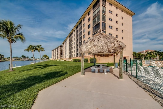 view of community with a patio area, a gazebo, a water view, and a lawn