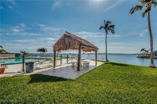 surrounding community featuring a swimming pool, a gazebo, a water view, and a lawn