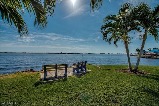 view of dock featuring a lawn and a water view