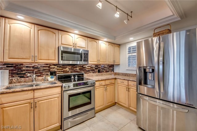 kitchen with light tile patterned floors, sink, light brown cabinets, and stainless steel appliances