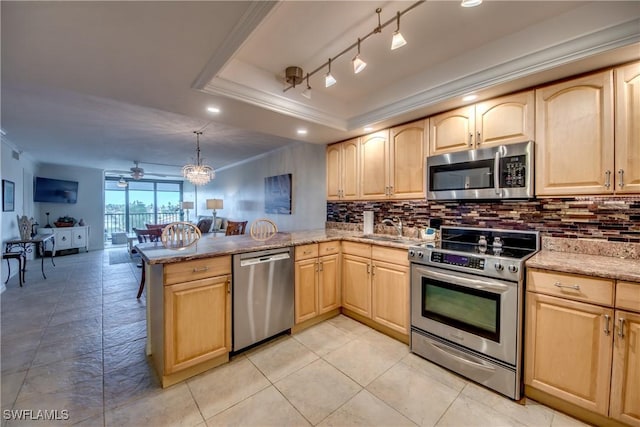 kitchen with decorative light fixtures, light brown cabinets, stainless steel appliances, kitchen peninsula, and a raised ceiling