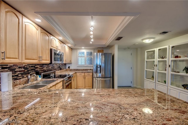 kitchen with light brown cabinets, stainless steel appliances, decorative backsplash, sink, and a raised ceiling