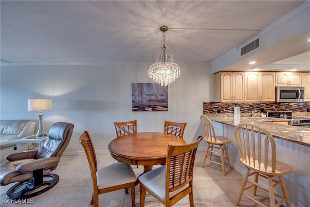 dining area featuring light tile patterned floors, a chandelier, crown molding, and sink