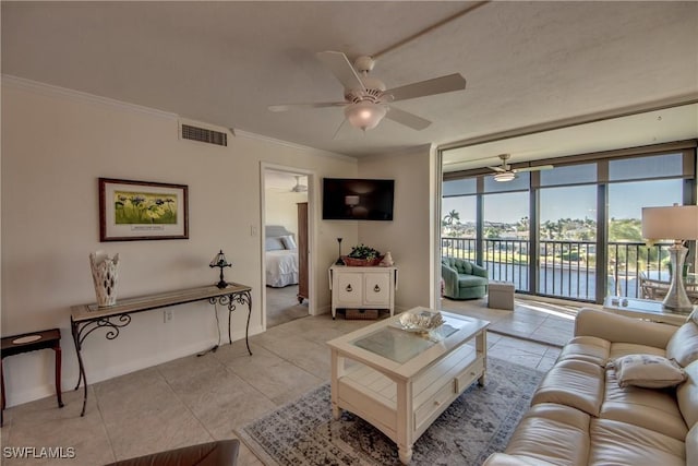 tiled living room with ceiling fan, a wall of windows, and crown molding